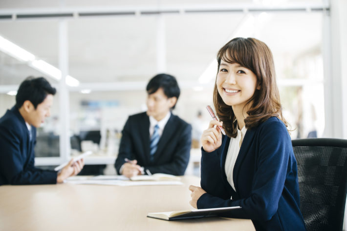 スーツの女性が笑顔でこちらをみている画像