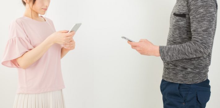 スマホを出して連絡先を交換する男女