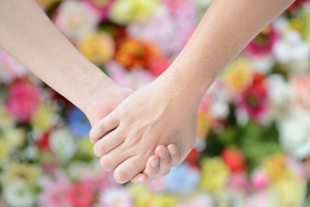 手を繋ぐ男女の写真