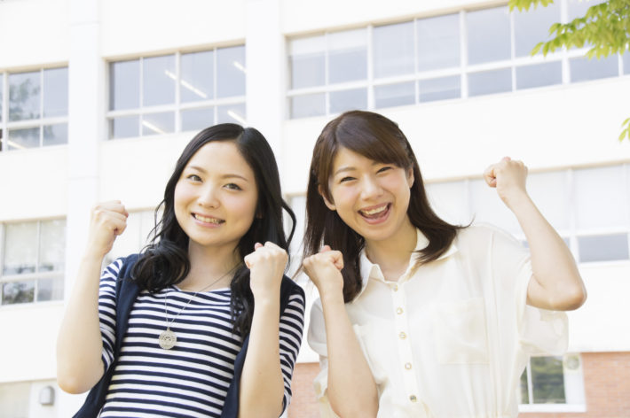 笑顔でガッツポーズをしている2人の女性