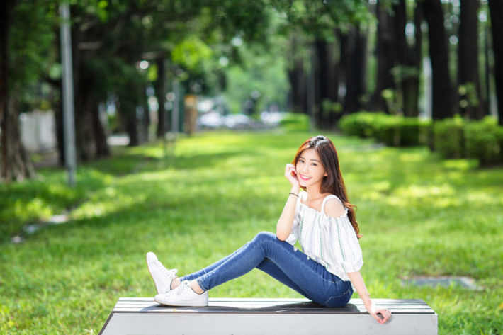 ベンチに座り頬杖をつく女性