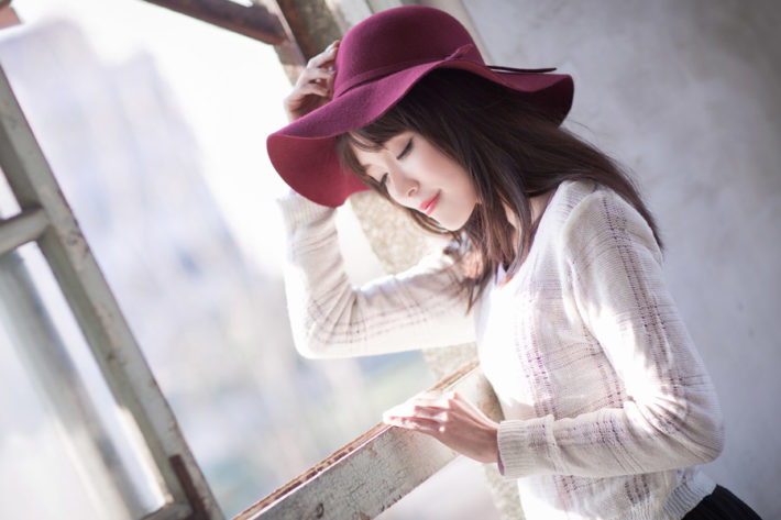 帽子を被り目を閉じている女性