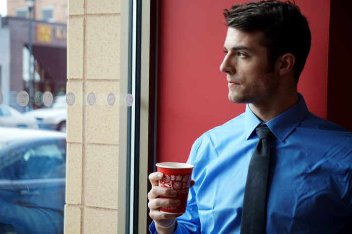 コーヒーを飲むスーツ姿の男性