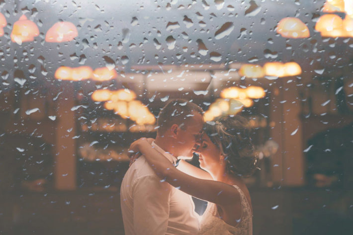 窓ガラスの前で抱きしめ合う男女