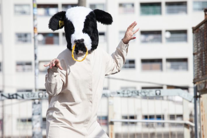 牛の被り物を被りポーズをとる女性