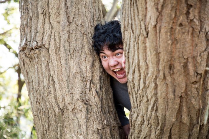 基の間から顔を出している男性