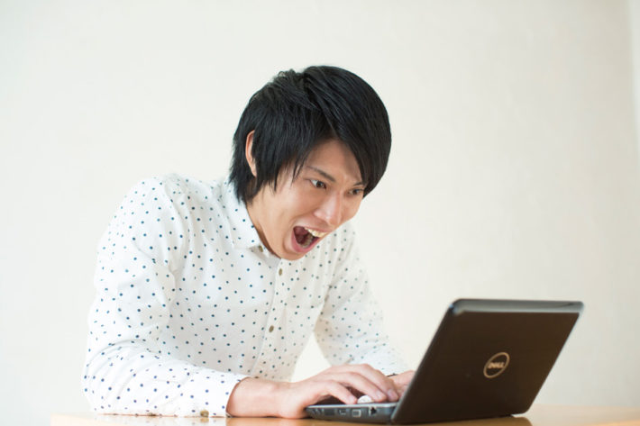 ノートパソコンで必死に仕事している男性
