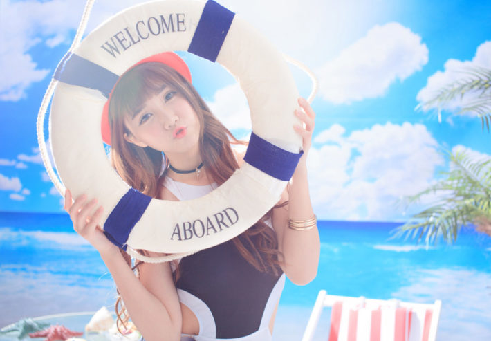 浮き輪の間から顔を出している水着の女性