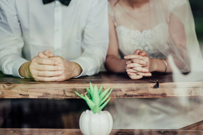 ウェディングドレスとタキシードを着て寄り添うカップル