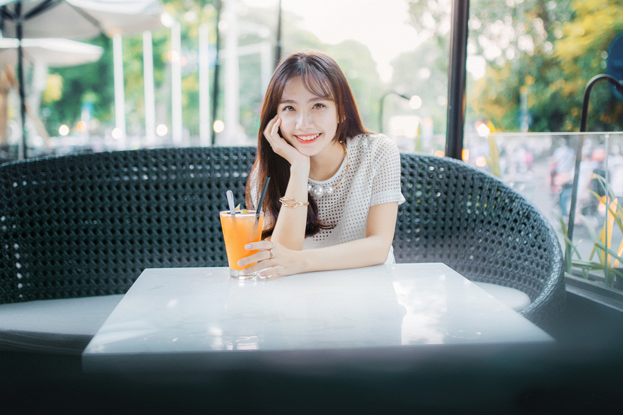 カフェでジュースを飲んで微笑んでいる女性