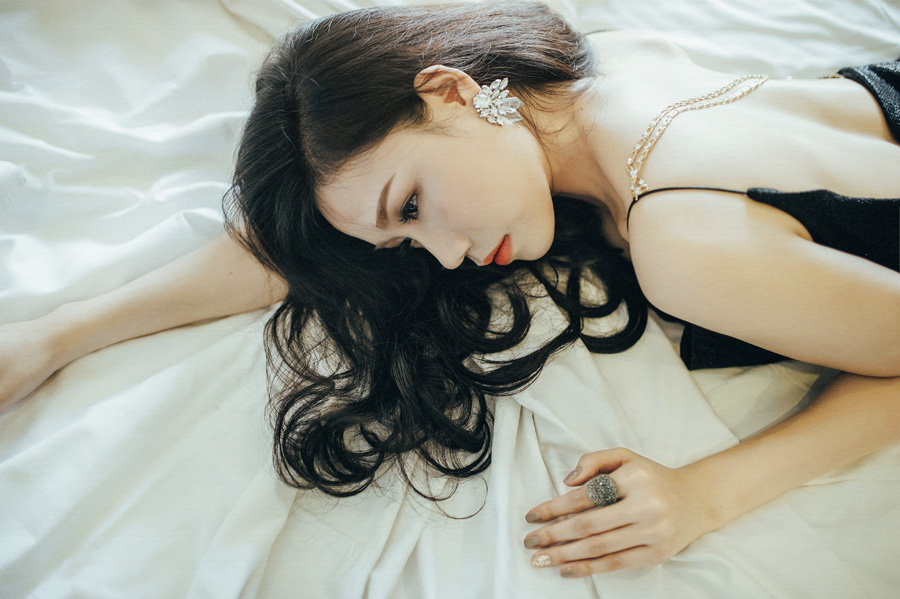 ドレス姿でうつ伏せに寝転んでいる女性