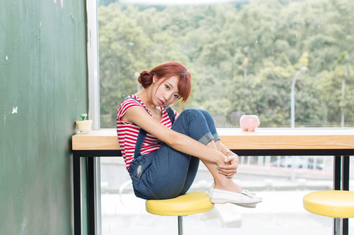 椅子の上で三角座りしている女性