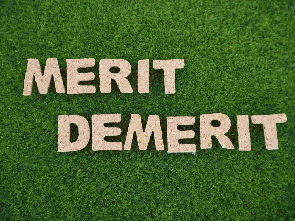 芝生の上に書かれたメリット、デメリットの文字