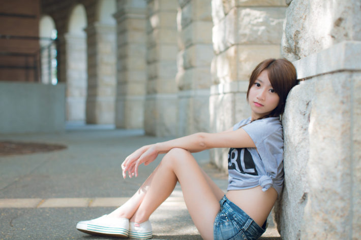 Tシャツと短パンを着て地面に座っている女性