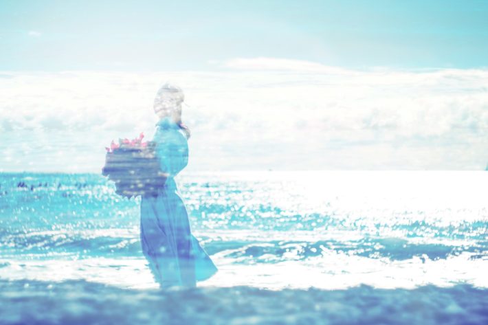 海辺で花束を持った女性