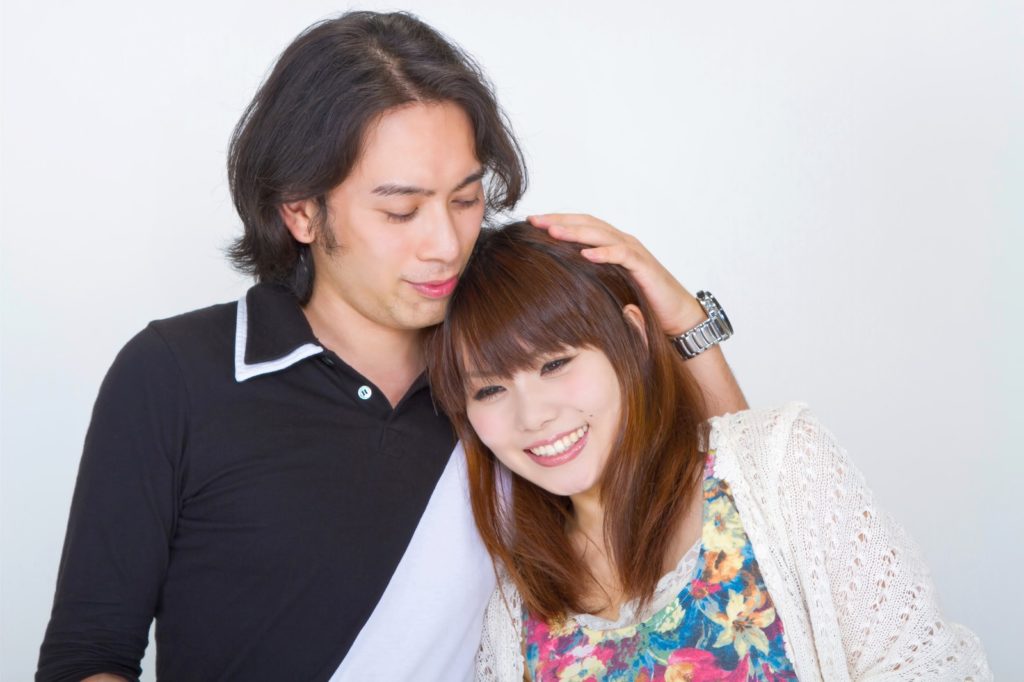 女性の頭を撫でている男性と甘えるブスな女性