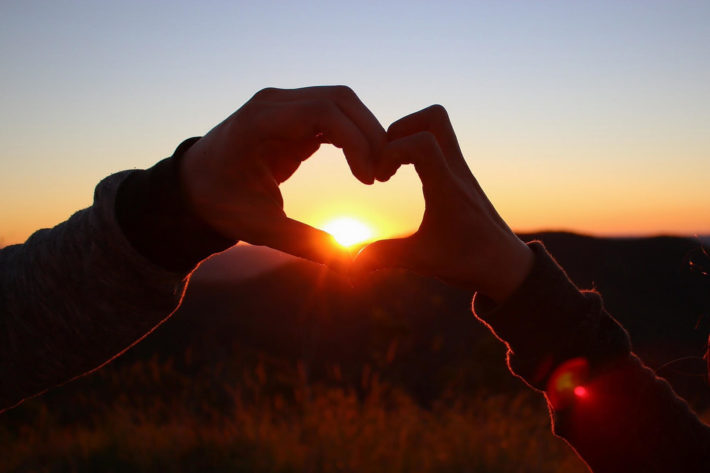 夕日にかざした手と手