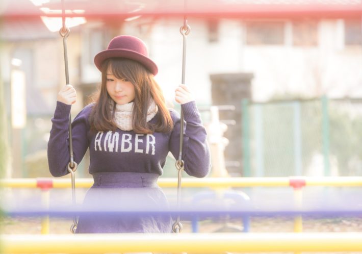 ブランコで考え事をする女性