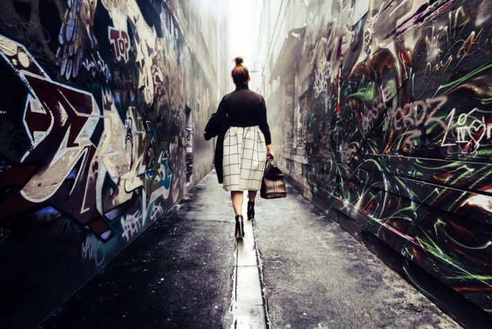 路地裏を歩き去っていく女性の後ろ姿