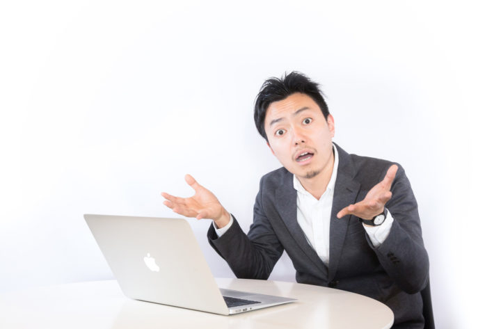 呆れ顔で両手を広げている男性