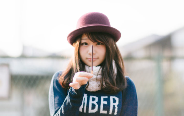 ポッキーを顔の前で立てている女性