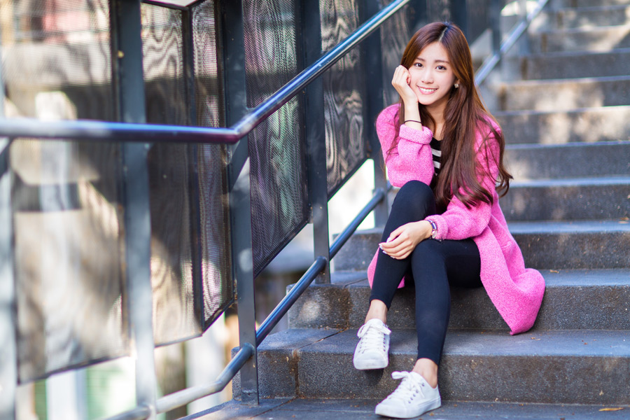 階段に座って頬杖をついている女性