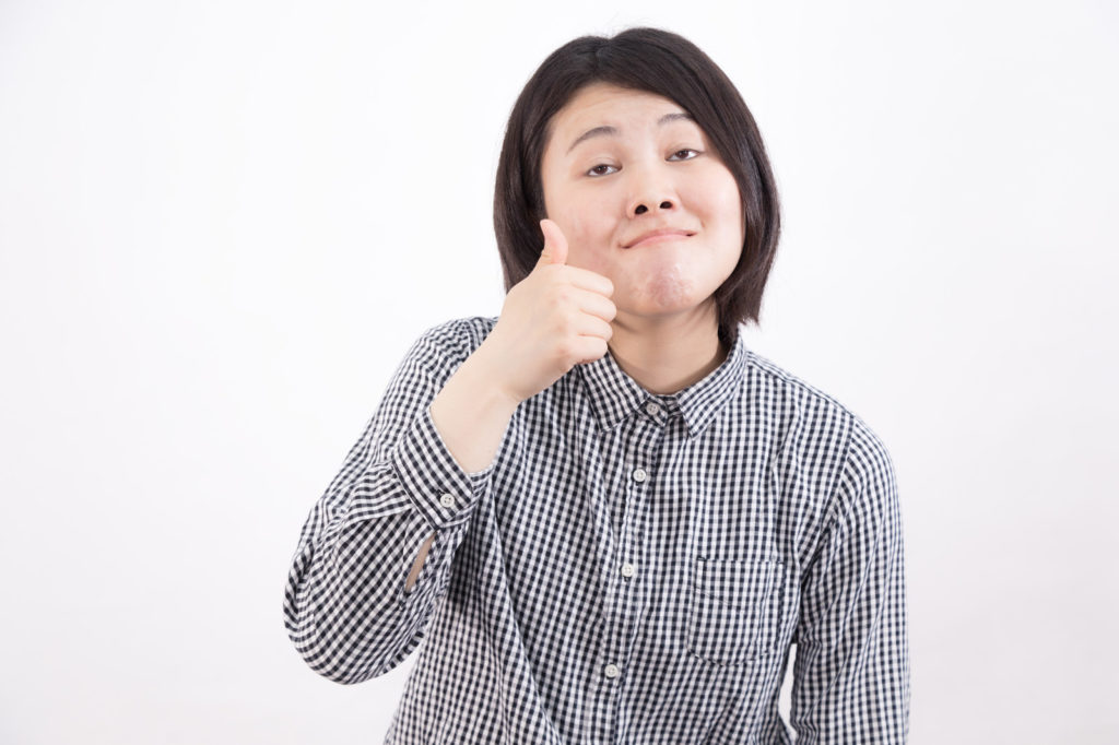変顔でサムズアップしている女性