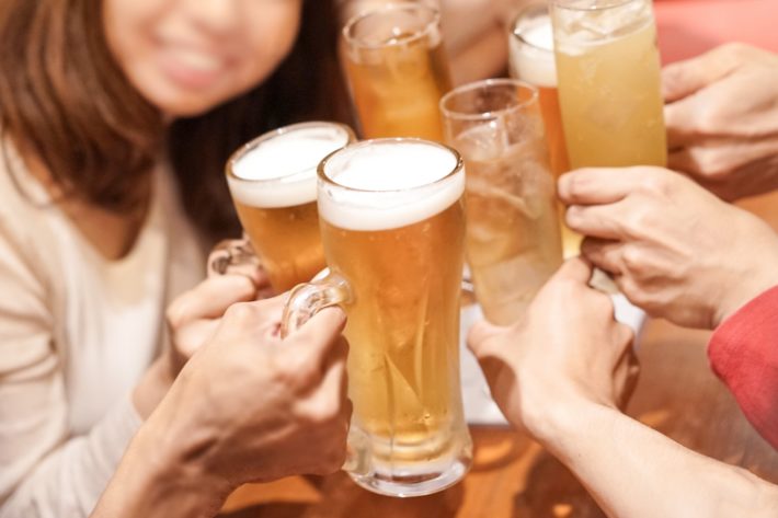 飲み会でわいわい乾杯している男女