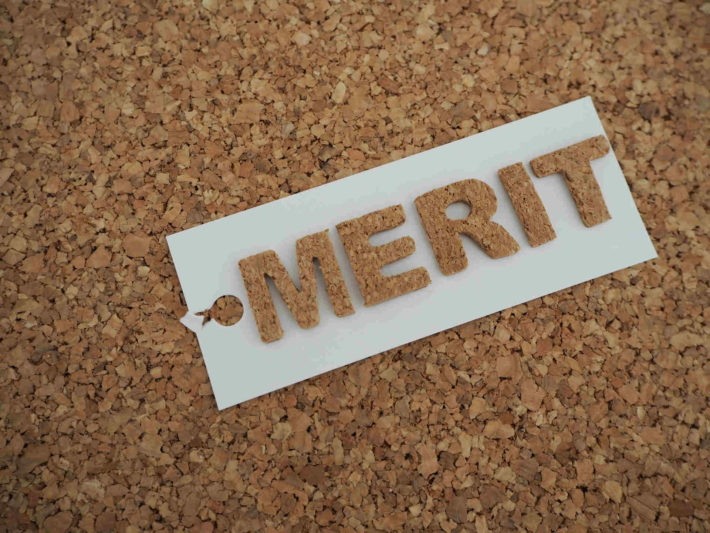 コルクボードに書かれたメリットの文字