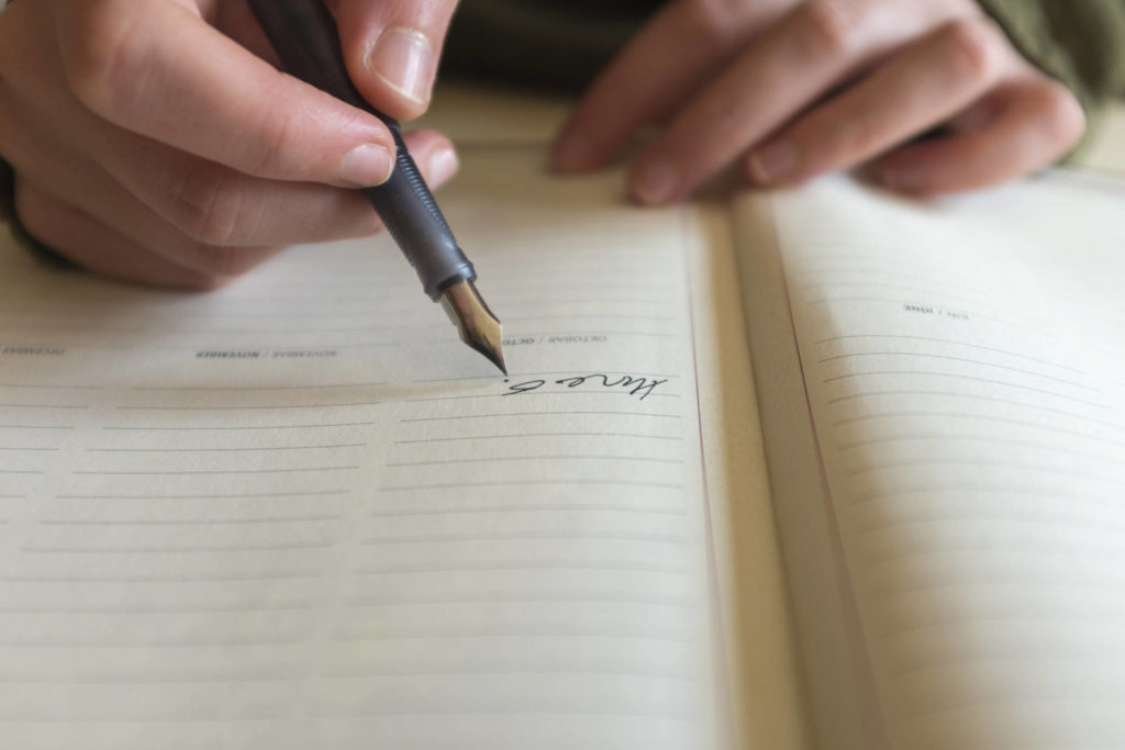 文字を書く男性の手元