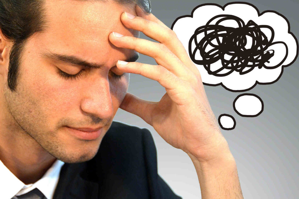 頭を抱えて悩んでいる外国人男性