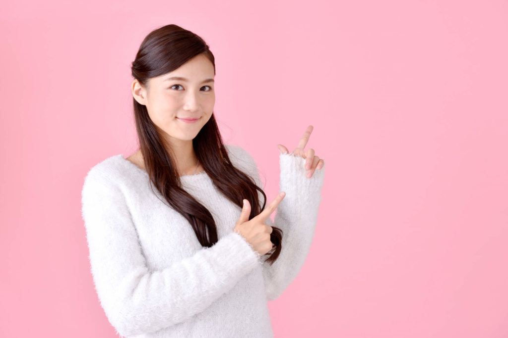 両方の指を指している女性