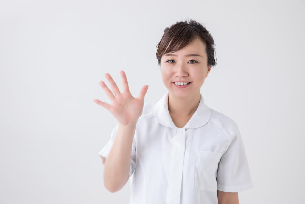 白衣の女性が手を広げ、5を示している画像