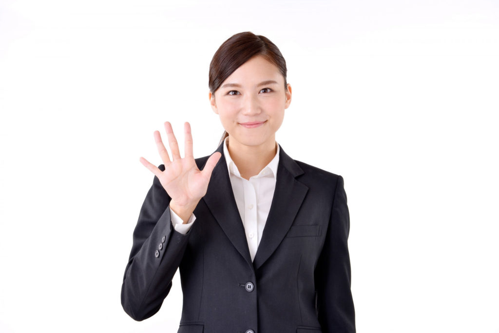 スーツの女性が手を広げ、5を示している画像