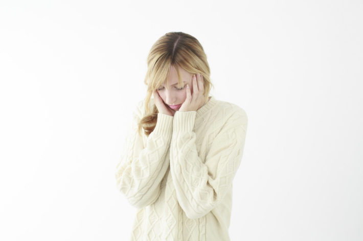 悩んで頭を抱えている外国人女性