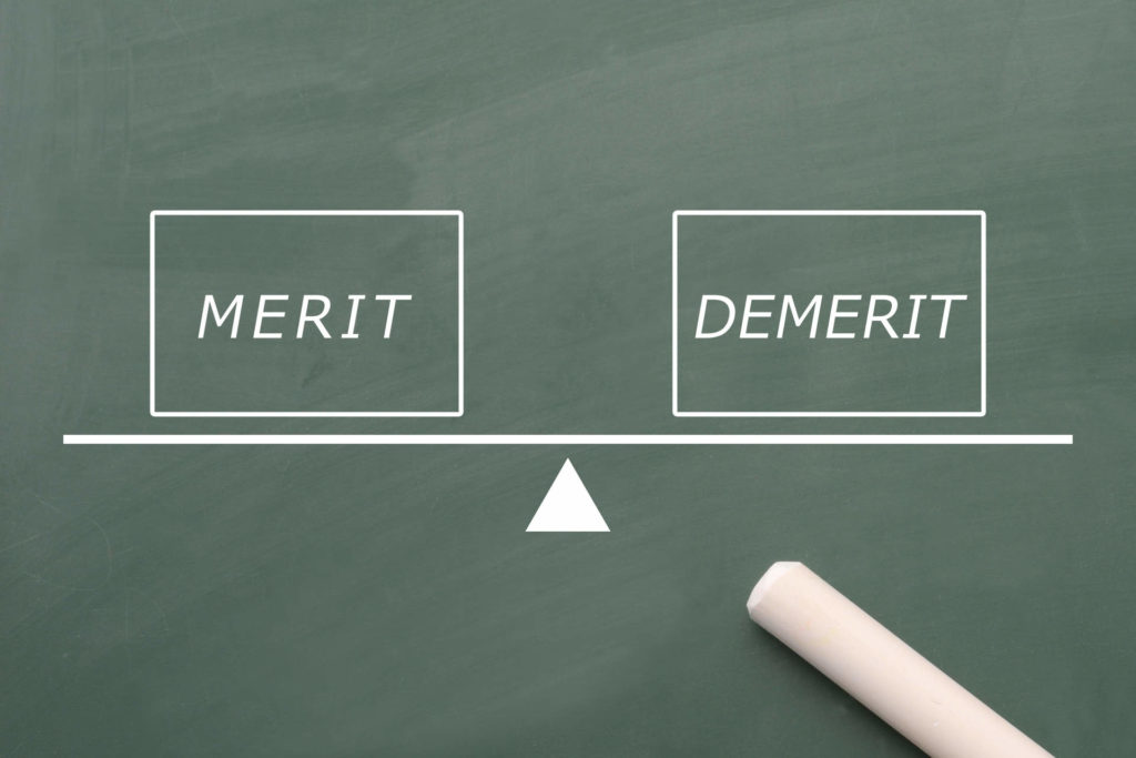 黒板に書かれたメリット、デメリットの文字