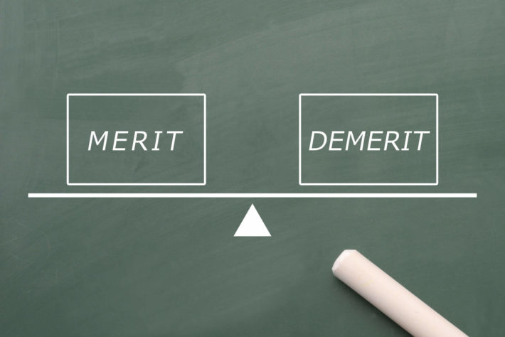 黒板に書かれたメリット、デメリットの文字