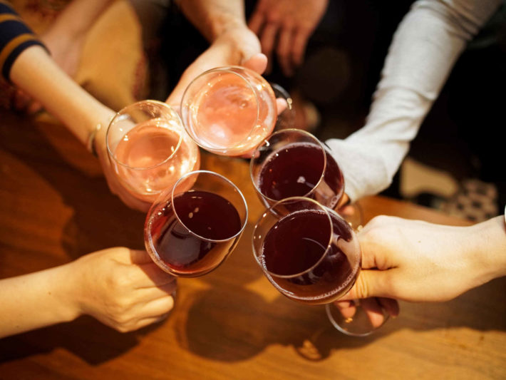 男女がグラスで乾杯し、パーティーしている画像