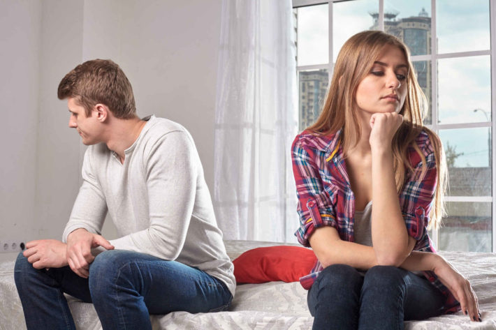 ベッドに座り喧嘩している外国人男女