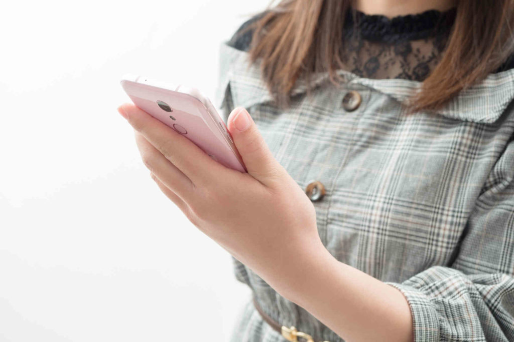 スマホを手に持ち場所を探している女性