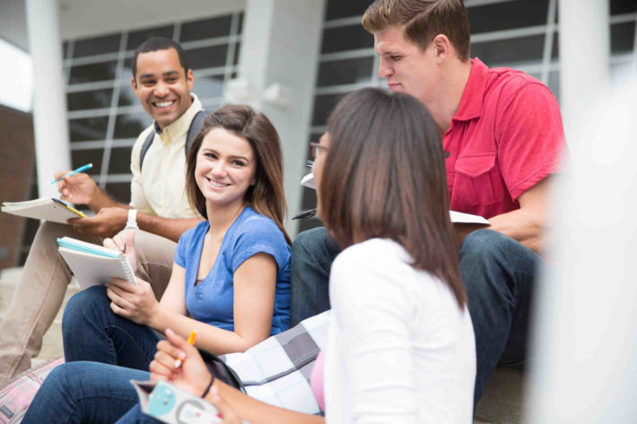 大学の学内で集まり話している男女