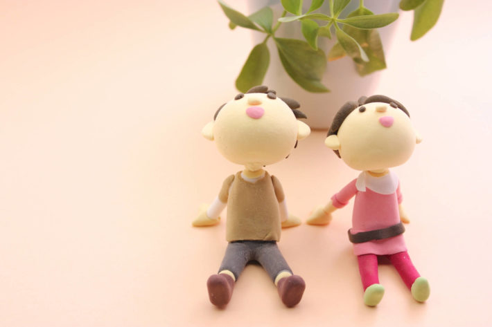 手をつないで座っているカップル人形