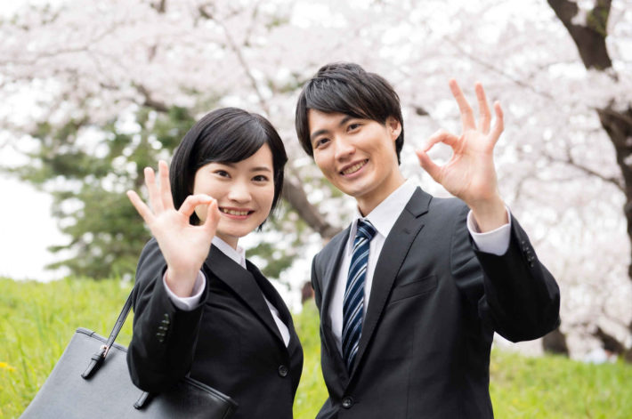 Goodサインを出す社会人の男女