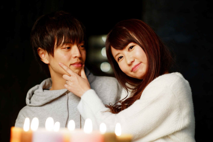 男性のほっぺを持ちニヤける女性