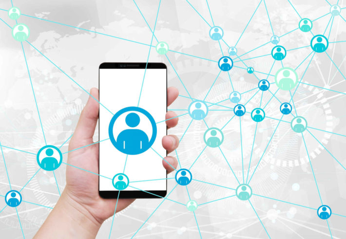 ネットワークに繋がったスマホを手に持っている画像