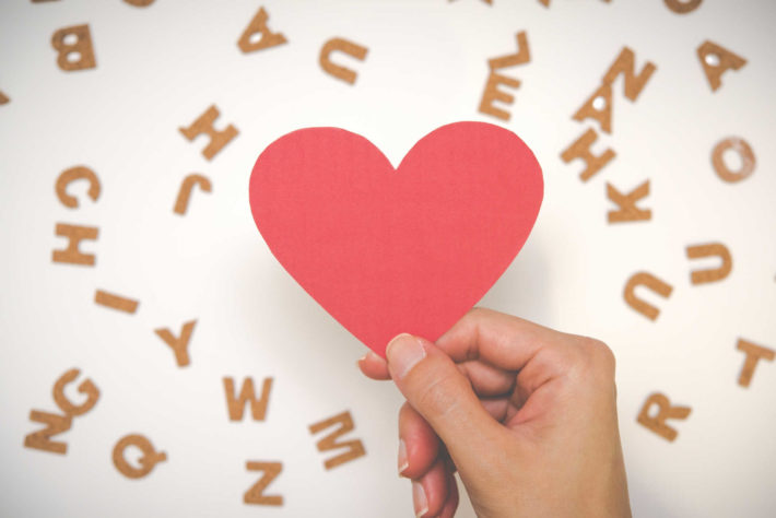 ハートの形に切った折り紙を手に持っている画像