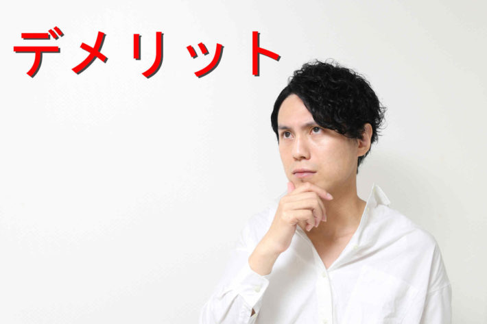 顎に手を当てて考え事をしている男性の画像