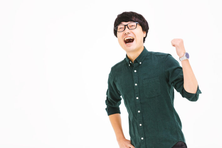 ガッツポーズをするオタク男子