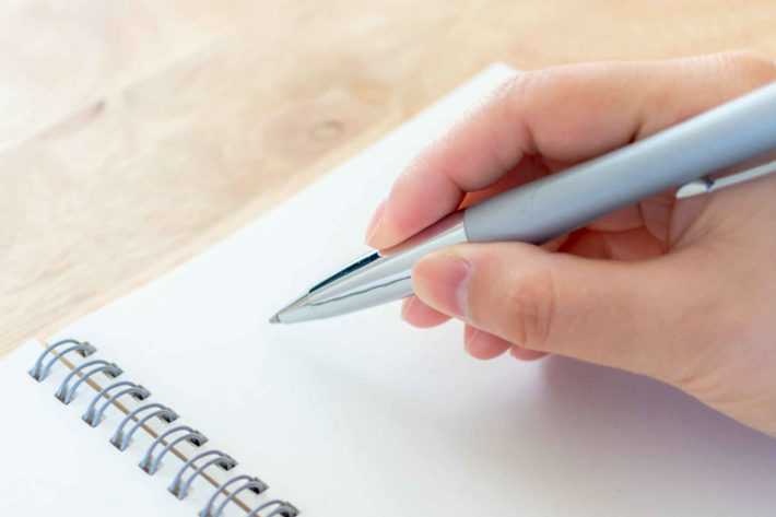 字を書く女性の手元