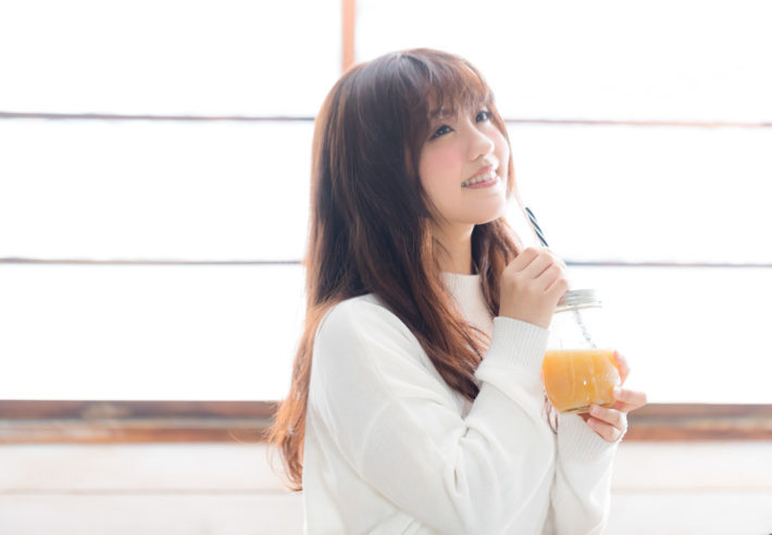 スムージーを飲んで満足そうに笑うモテ女